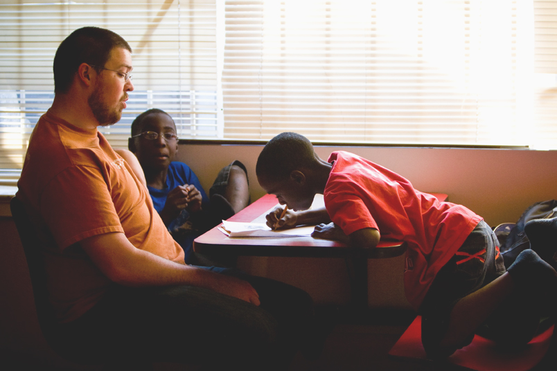 Today is a typical Monday afternoon for Ben Lowe, patiently helping Tyquel (left) and Keman with their homework.
