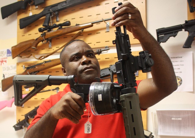 Michael Cargill, 44, shows an AR-15 in his shop, Central Texas Gun Works, in Austin. Cargill led a boycott of Groupon after the company banned most firearm-related deals. Photo by Eva Lorraine Molina.