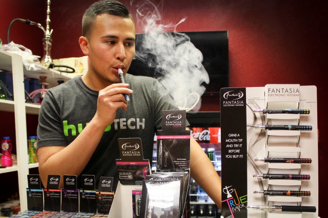 Albert Toca, owner of Ontario Hookah Lounge on East Riverside Dr., demonstrates the how to smoke an E-cigarette. Photo by Jhannet Sanchez.