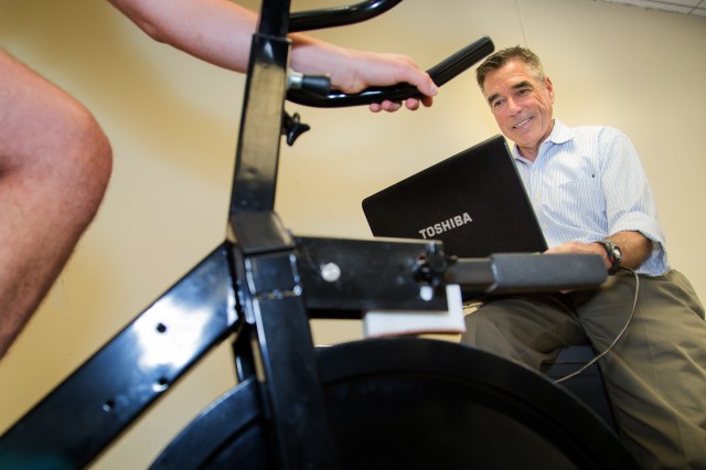 Professor Edward Coyle monitors the training of student athletes using his invention, the PowerCycle. Photo by Martin do Nascimento.