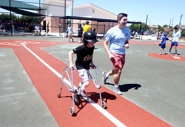 Bradyn Taylor along with his buddy Ian Hankes runs towards the first base during a baseball game between Astros and Dodgers. The game was played as a part of Miracle League - Austin, which caters to children who have disabilities ranging from autism to cognitive, and physical disabilities. Photo by Shweta Gulati