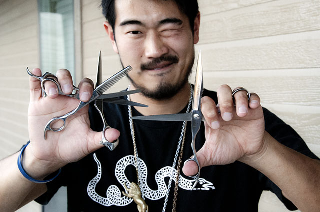 Aaron Ko displays the three models of scissors he sells, including the new texturizer with a serrated blade. Photo by Oscar Ricardo Silva