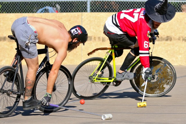 Two bike polo players fight over the ball in an intense game of the sport at the South Austin Recreation Center.