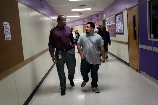 Ricky Williams, graduation coach with the Austin Independent School District, walks the hallways with Jose Martinez-Duran, a senior at LBJ High School in Austin on Friday, February 20, 2015. Martinez-Duran is now on track to graduate on time after working with Williams since his sophomore year. Lukas Keapproth/Reporting Texas