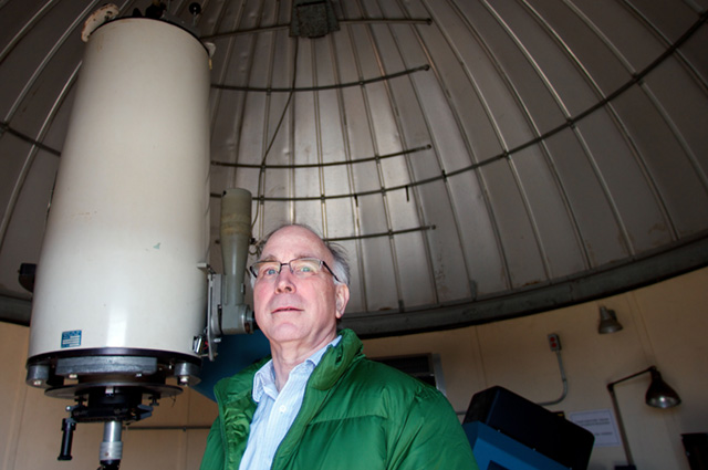 Professor William Cochran, poses in front of a telescope on top of the Robert Lee Moore Hall at the University of Texas. Cochran, and several other professors, have been doing research on exoplanets and in the next couple of years, they hope to make improvements to another telescope at the McDonald Observatory that will help them see if the exoplanets have life on them. Photo by Kiera Dieter.