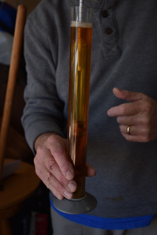 Cary Camden shows off the color of his wort after measuring its specific gravity. Ye Jin Kim/Reporting Texas