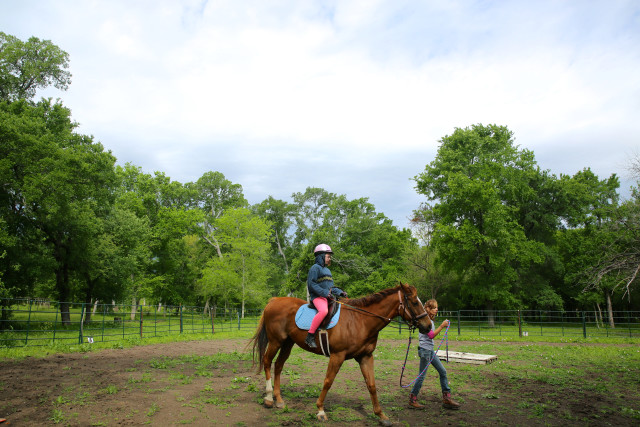 Jozlynn Stevens (right), 11, starts her therapeutic riding session at the Healing with Horses Ranch, in Manor, Texas, with the accompany of her riding instructor on a Friday morning. She has been working with therapy horses for three years. Qiling Wang/Reporting Texas