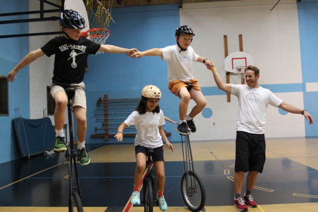 Jimmy Agnew (right), founder of One Wheel Many Children, helps St. Andrew's students take turns on the tall unicycle on May 6, 2016 in Austin,TX. The former St. Andrew's Episcopal teacher has taught hundreds of kids to unicycle over the past eight years before founding a unicycle nonprofit. Anna Casey/Reporting Texas