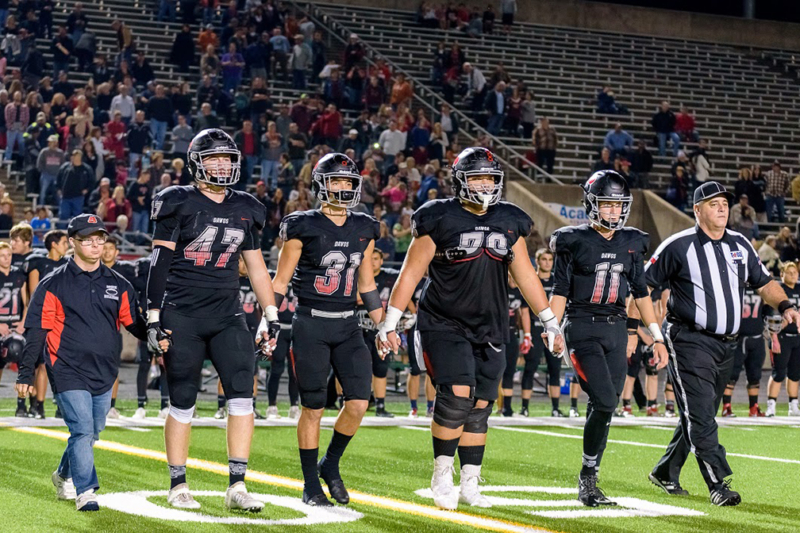 James Bowie High School athletic trainer Jacob Wempe holds hand of senior linebacker Ashton Rogers to midfield for the coin toss of Friday’s opening round playoff game against Pflugerville Hendrickson at Toney Burger Stadium. Photo courtesy: JR Smith for Reporting Texas