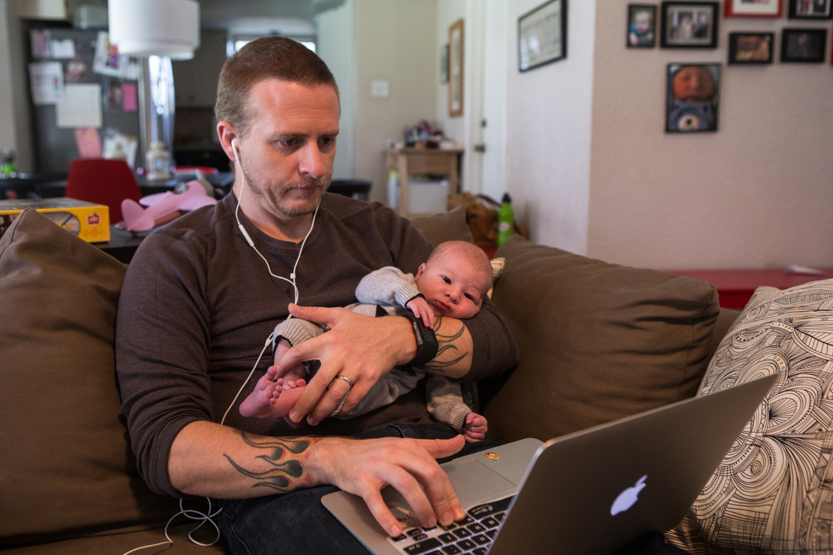 Veteran Eric Burleson holds his newborn son, Emerson, at his home in Austin, Texas on November 10, 2016.. Burleson is multitasking, working his job in Austin's tech industry from home while on paternity leave.